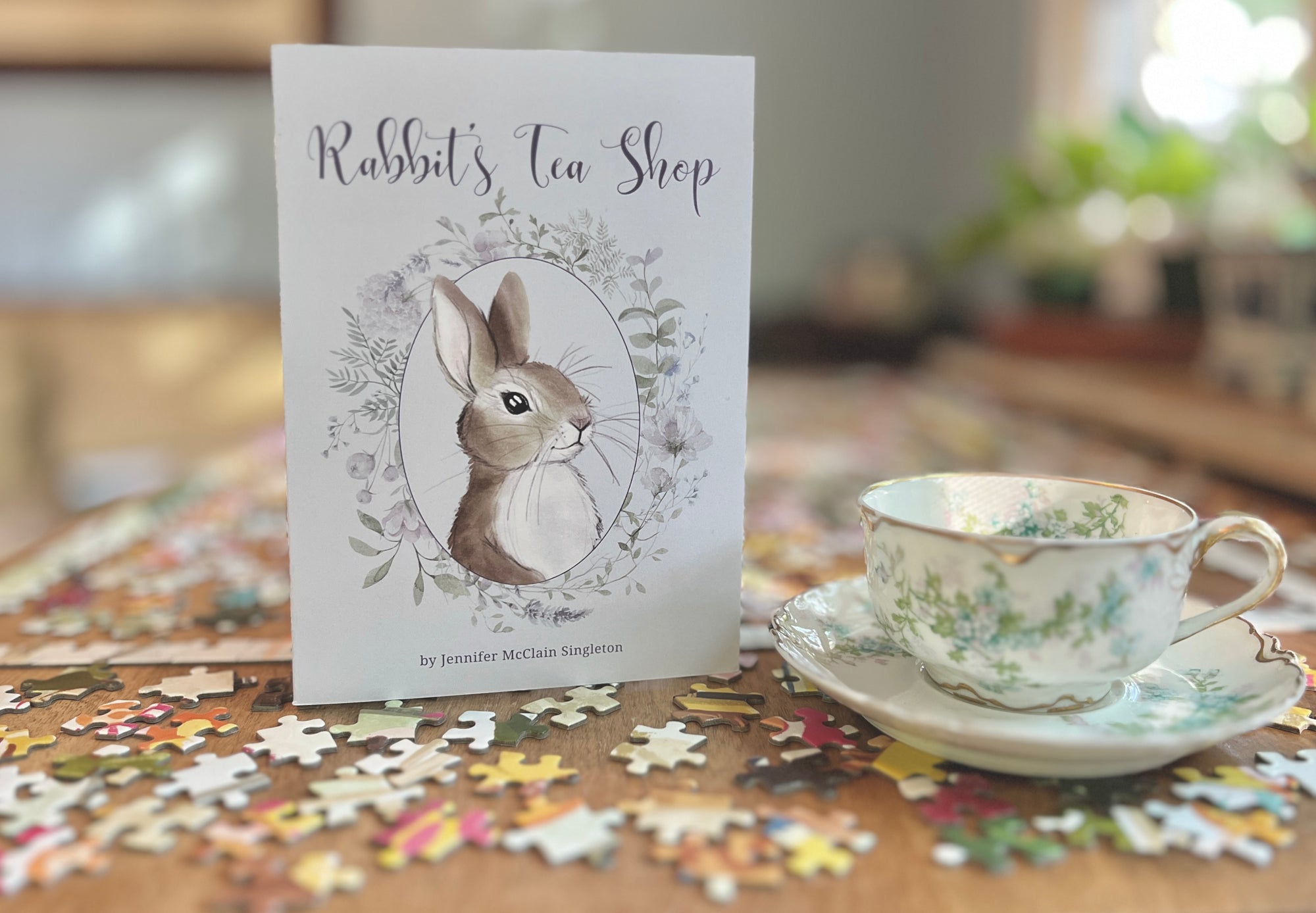 Rabbit's Tea Shop book, sitting on a table with a jigsaw puzzles and a teacup