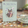 book (Mr. Owl's Book Fair) sitting on a table with a jigsaw puzzle and a teacup